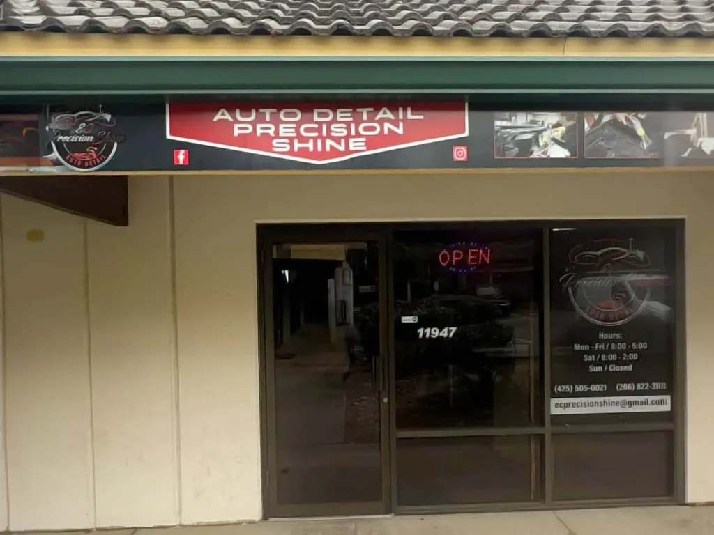 storefront of e&c precision shine auto detailing in kirkland with green awning and red "open" sign