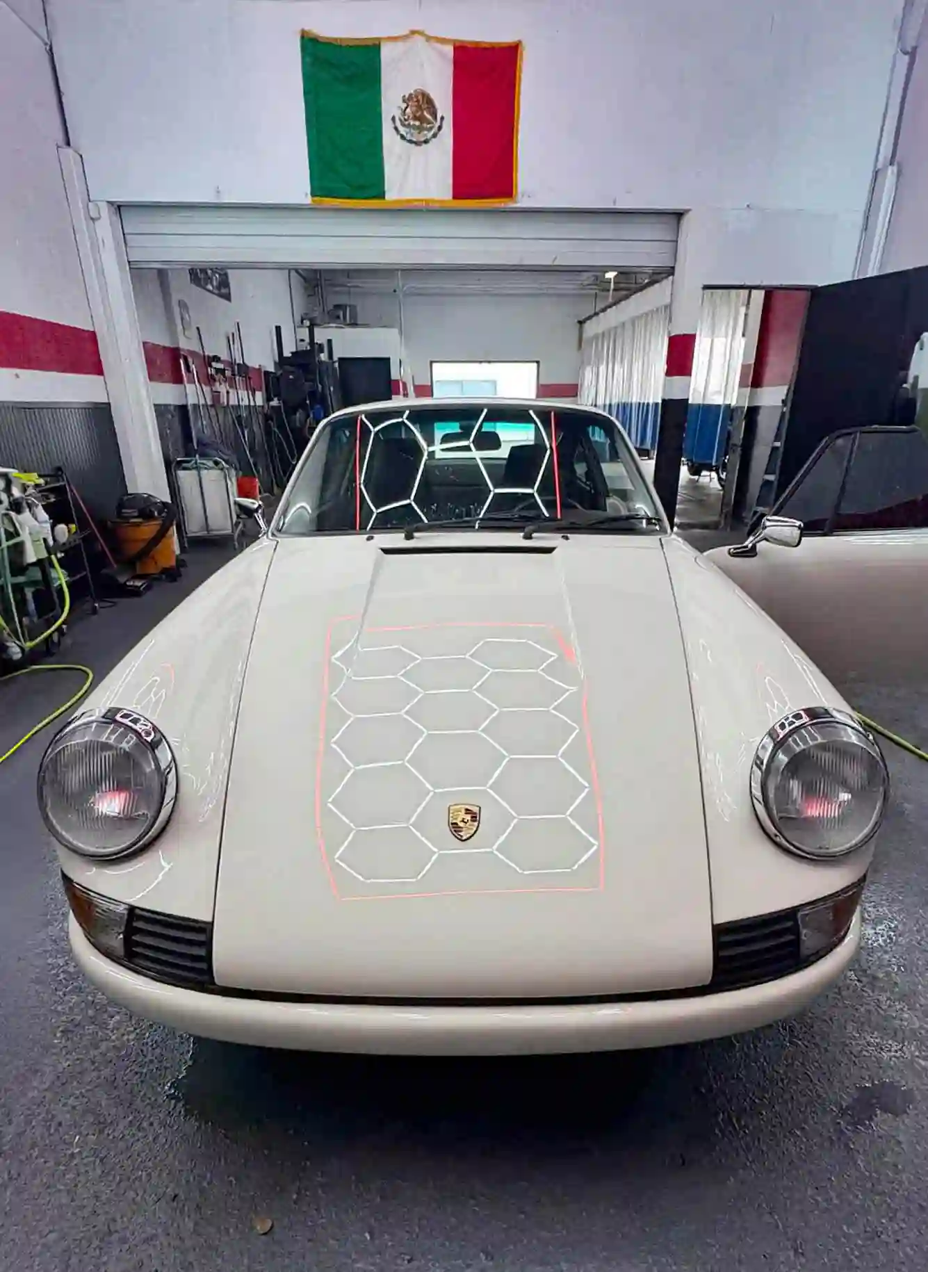 beige porsche 911 in detailing garage with ceramic coating and hexagonal water beading under bright lights