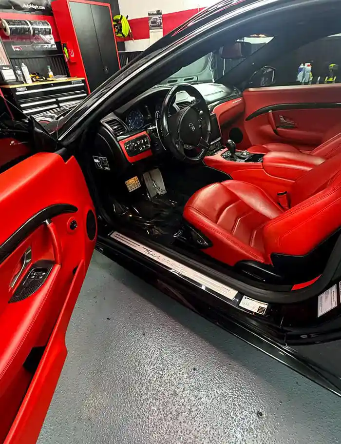 red leather interior of luxury coupe with custom seats and red stitching